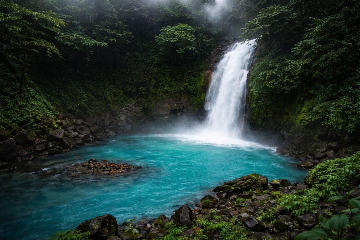 Tropical waterfall flowing into a blue pool near Arenal Volcano, photographed during a guided excursion with Arenal Volcano Costa Rica Tours